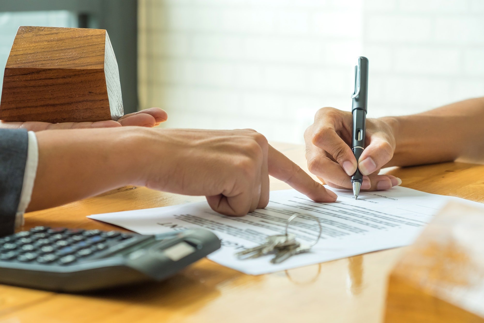 Buyers are signing a home purchase agreement from a broker.